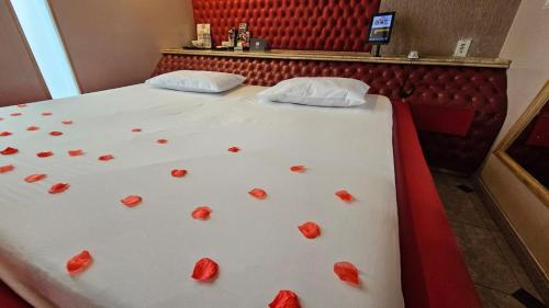 a bed with red rose petals on it at A2 suites - Hotel e Motel in Brasilia