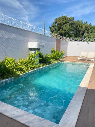 una piscina con acqua blu in un cortile di Aconchego! Sua casa com Piscina em Passos!! a Passos