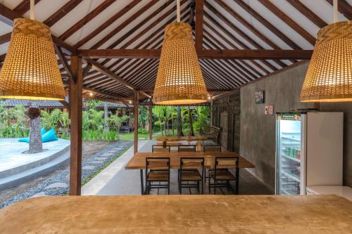 a restaurant with wooden tables and chairs and lights at Tahlia's Villa in Sorongjukung