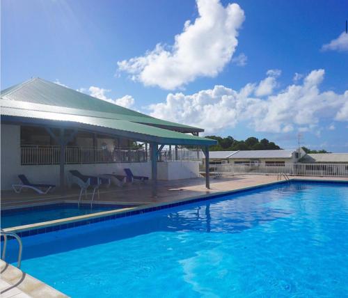a swimming pool in front of a building at Duplex piscine vue imprenable Marina du Gosier avec citerne in Le Gosier