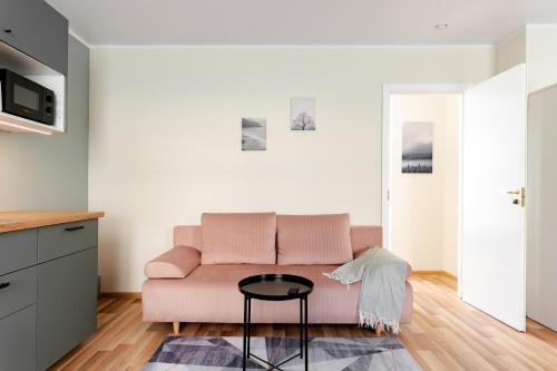 a living room with a pink couch and a table at Liidia Apartments in Haapsalu