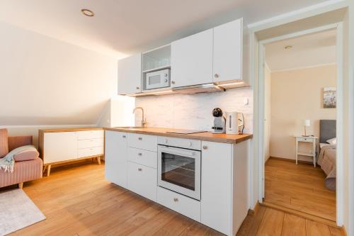 a kitchen with white cabinets and a counter top at Liidia Apartments in Haapsalu