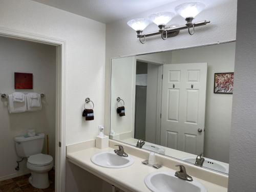 a bathroom with two sinks and a mirror and a toilet at Mount Shasta Resort in Mount Shasta