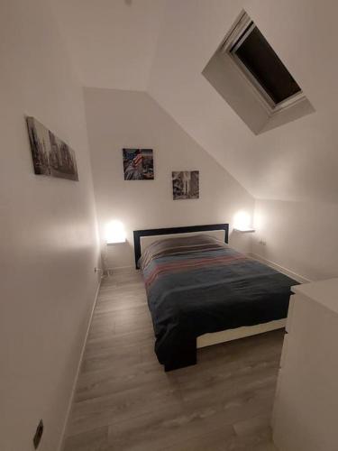 - une chambre avec un lit et deux lumières sur le mur dans l'établissement Maison calme proche de la cité des loisirs, à Amnéville