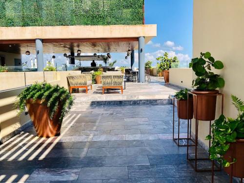 a patio with chairs and potted plants at 1 block from the Ocean and 5thAV in Playa del Carmen