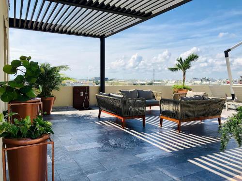 a patio with chairs and a couch on a roof at 1 block from the Ocean and 5thAV in Playa del Carmen