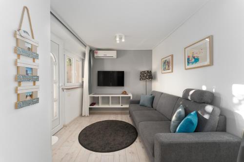 ein Wohnzimmer mit einem Sofa und einem TV in der Unterkunft Apartments Palma Rabac in Rabac