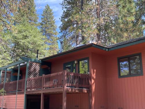 a red house with a deck and trees at Mount Shasta Resort in Mount Shasta