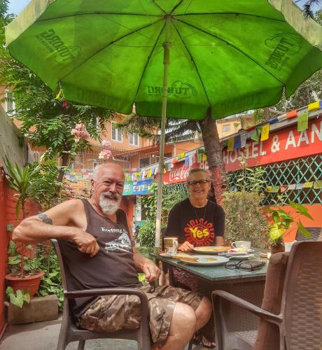 a man sitting in a chair under a green umbrella at Best Hostel in Kathmandu