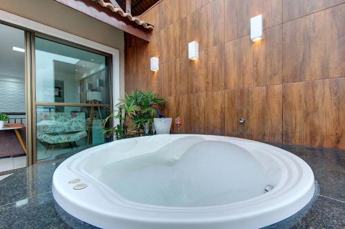 una gran bañera blanca en una habitación en Cobertura Duplex Jacuzzi - Mediterranee Residence, en Aquiraz