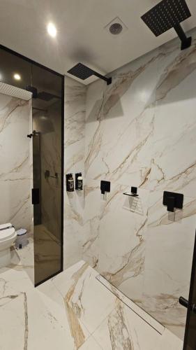 a marble bathroom with a shower and a toilet at A2 suites - Hotel e Motel in Brasilia