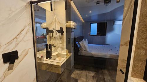 a bathroom with a glass shower with a sink at A2 suites - Hotel e Motel in Brasilia