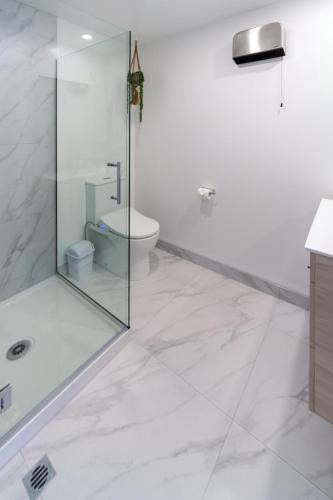 a bathroom with a glass shower and a toilet at Cozy 2 Bedroom Near City Biking and Trails in Christchurch