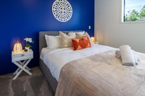 a blue bedroom with a large bed and a table at Cozy 2 Bedroom Near City Biking and Trails in Christchurch