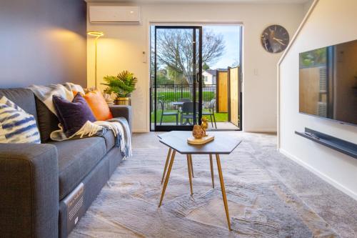 a living room with a couch and a table at Cozy 2 Bedroom Near City Biking and Trails in Christchurch