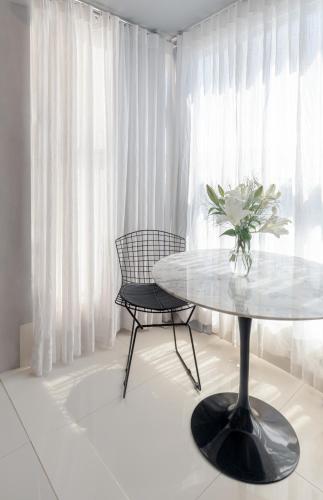 a table and two chairs and a vase of flowers at PALMAS EXPERIENCE - APARTAMENTO VISTA LAGO, próximo ao shopping in Palmas