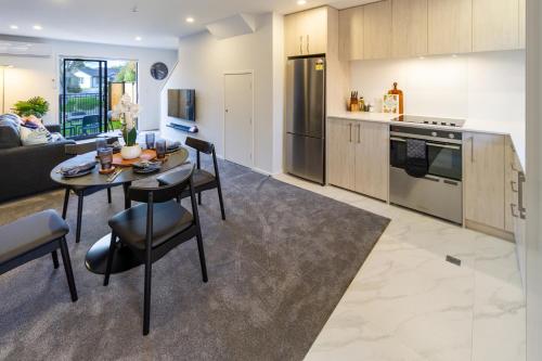a kitchen and living room with a table and chairs at Cozy 2 Bedroom Near City Biking and Trails in Christchurch