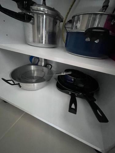 a kitchen shelf with a pot and a sink at Aparta hotel aviva in Santa Marta