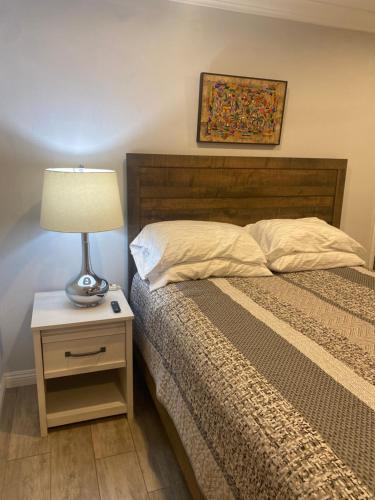 1 dormitorio con cama y mesita de noche con lámpara en Windsor Room en Phoenix