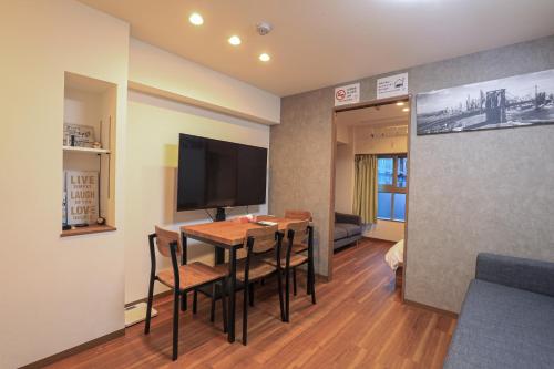 a room with a table with chairs and a television at self-check in-5mins walk from shinokubo station free wifi in Tokyo