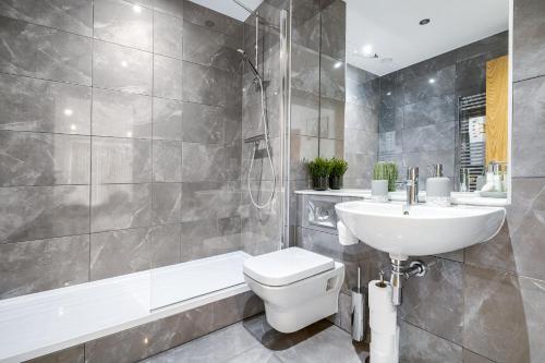 a bathroom with a sink and a toilet and a bath tub at Pluxa Emerald Luxury - Walk to Attractions, Transport Nearby in Birmingham