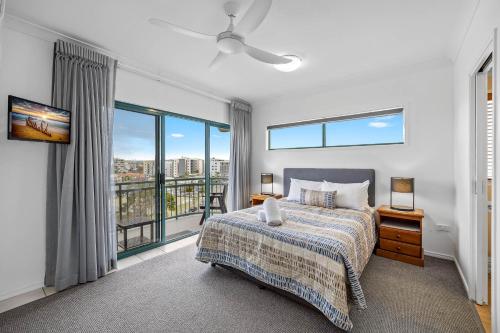 a bedroom with a bed and a large window at Sunshine Towers Boutique Apartments in Maroochydore