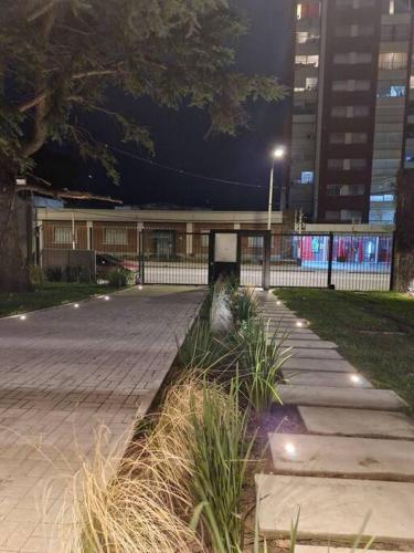 a walkway in a park at night with a building at Excelente ubicación, nuevo, luminoso! in Montevideo