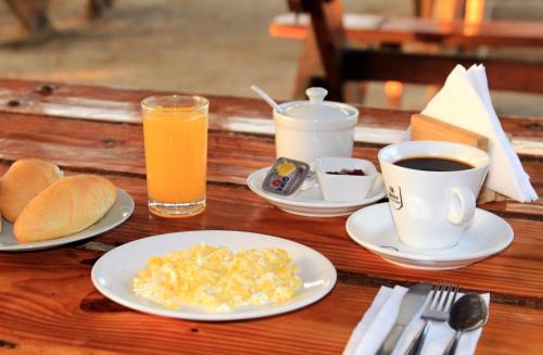 una mesa con platos de huevos y tazas de café en Bamboo Paracas Resort, en Paracas