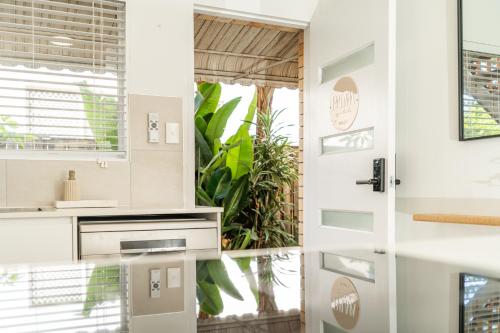 a kitchen with a white door and a window at PALMA - Couples Beach Shack! in Gold Coast