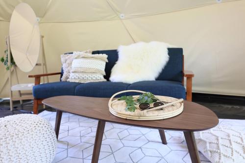 a living room with a blue couch and a table at NORTH GLAMPER 富良野 in Kami-furano