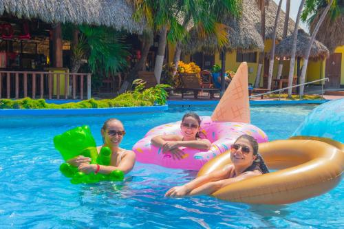 three people laying on inflatables in a swimming pool at Nandel Beach Resort in La Cruz