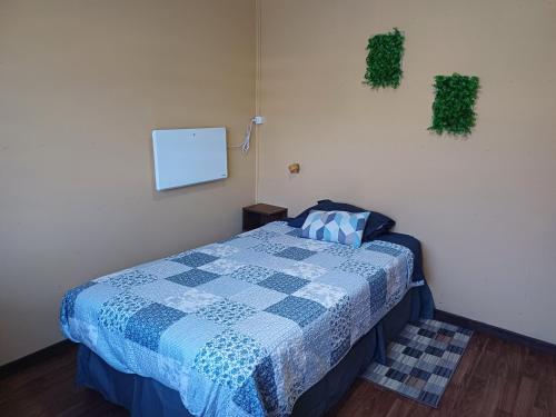 Casa Celeste في بونتا أريناس: غرفة نوم بسرير ولحاف ازرق وابيض