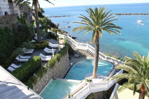 a beach with palm trees and palm trees at Hotel Helvetia in Sestri Levante