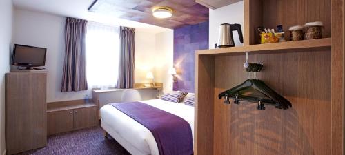um quarto de hotel com uma cama e uma televisão em Kyriad Valence Nord Bourg-Les-Valence em Bourg-lès-Valence