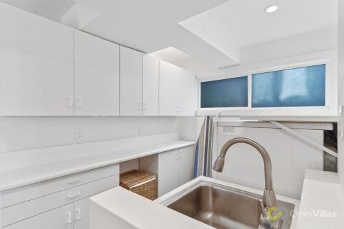 uma cozinha com armários brancos e um lavatório em Stunning Views by the Bay 2BR em Brisbane