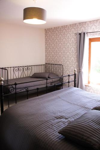 a bedroom with two beds and a window at Gîte Le Bol d'Air in Puilly-et-Charbeaux
