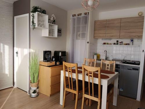 une cuisine avec une table et des chaises dans une pièce dans l'établissement Charmant appartement avec balcon, WIFI, parking privatif, à proximité de la plage et du centre-ville. - FR-1-712-20, à Villers-sur-Mer