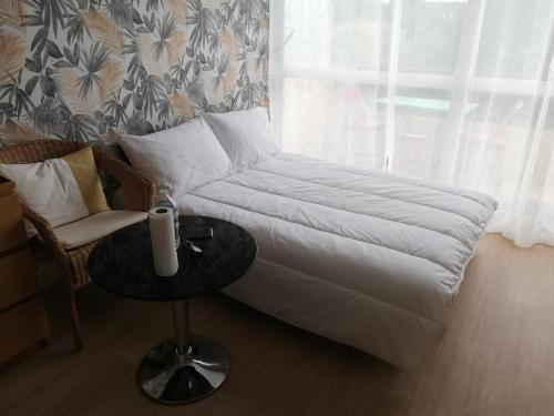 sala de estar con cama, mesa y ventana en Appartement Villers-sur-Mer, 1 pièce, 4 personnes - FR-1-712-20, en Villers-sur-Mer
