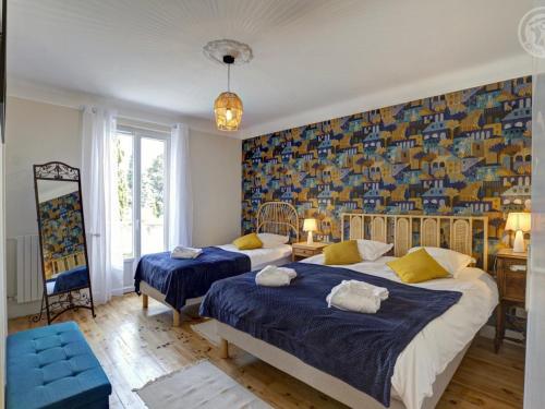 1 dormitorio con 2 camas y una pared colorida en Gîte Montbrison, 5 pièces, 9 personnes - FR-1-496-309, en Montbrison