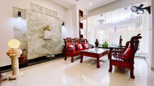 a living room with red chairs and a table at Moon Homestay Huế in Thôn Dương Xuân Hạ