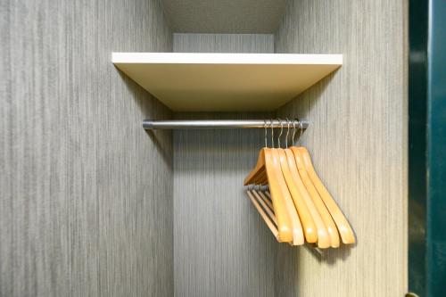 a rack with two wooden utensils on a wall at Hotel Econo Kameyama in Kameyama