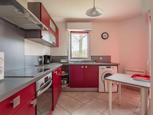 une cuisine avec des armoires rouges et un évier dans l'établissement Appartement Moderne avec Terrasse – 700m des Commerces, St-Jean-de-Luz - FR-1-4-564, à Saint-Jean-de-Luz