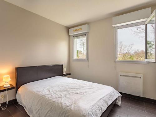 une chambre avec un grand lit et deux fenêtres dans l'établissement Appartement Moderne avec Terrasse – 700m des Commerces, St-Jean-de-Luz - FR-1-4-564, à Saint-Jean-de-Luz