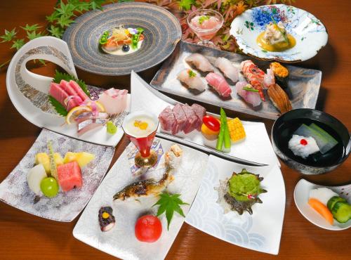 una tabella ricoperta con diversi tipi di alimenti su piatti di 原鶴の舞 ad Asakura