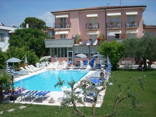 a hotel with a large swimming pool in front of a building at Cà Masawalsa Hotel in Bardolino