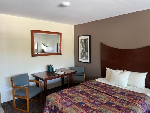 Habitación de hotel con cama, mesa y escritorio. en All Star Inn & Suites en Wisconsin Dells
