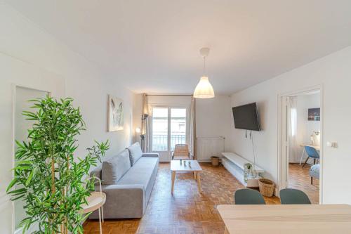 un salon avec un canapé et une télévision dans l'établissement Le Jardin d’Alexandre cosy 4 pers Charpennes, à Villeurbanne