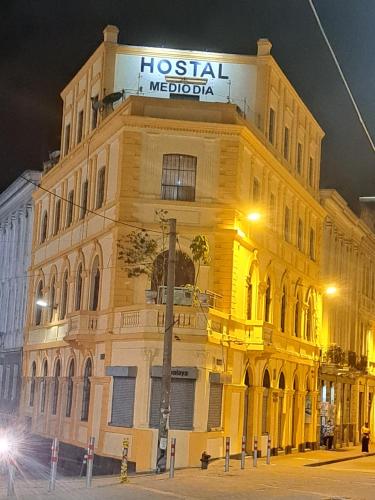 un edificio giallo con un cartello sopra di Hostal Mediodia a Quito