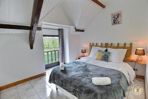 une chambre avec un lit et une grande fenêtre dans l'établissement Fremur, à Pluduno