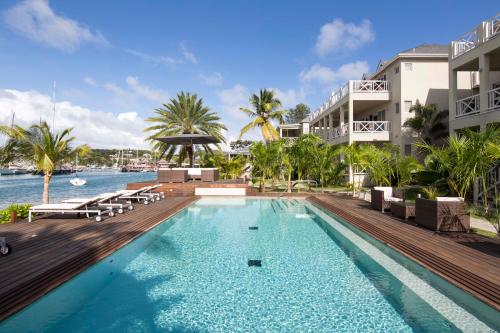 a swimming pool next to a building with a resort at South Point Antigua in English Harbour Town